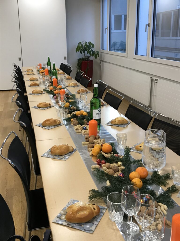 Schön gedeckter Tisch mit Gritibänz, Mandarinen, Schöggeli und Kerzen